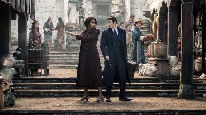 Jessica Williams ve Callum Turner, Fantastic Beasts 3'te bir sokakta arka arkaya duruyor.