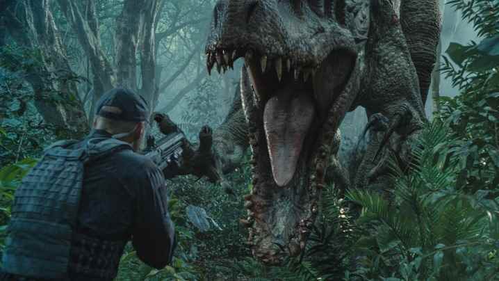 Indominus Rex, Jurassic World'de silahlı bir güvenlik görevlisini öldürmek üzere.