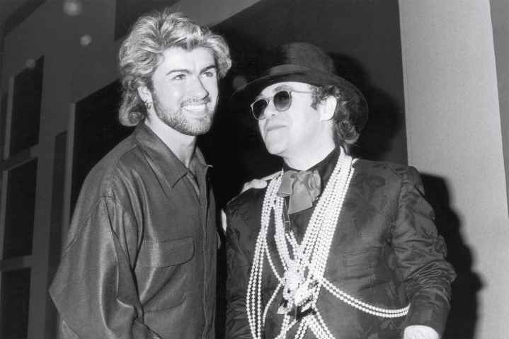 Pop yıldızı Elton John (sağda), 13 Mart 1985'te Londra'daki Grosvenor House Hotel'de Ivor Novello Yılın Söz Yazarı Ödülü'nü kazandığı için George Michael'ı tebrik ediyor.