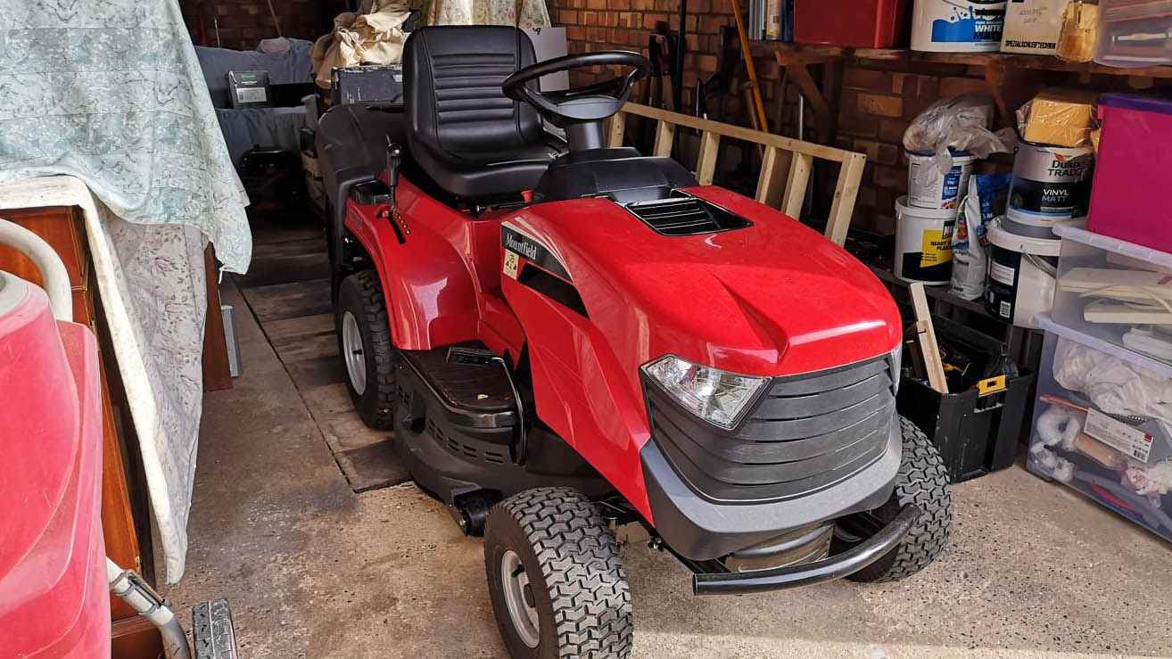 Mountfield 1330M, bir garajda saklanan çim biçme makinesine biniyor