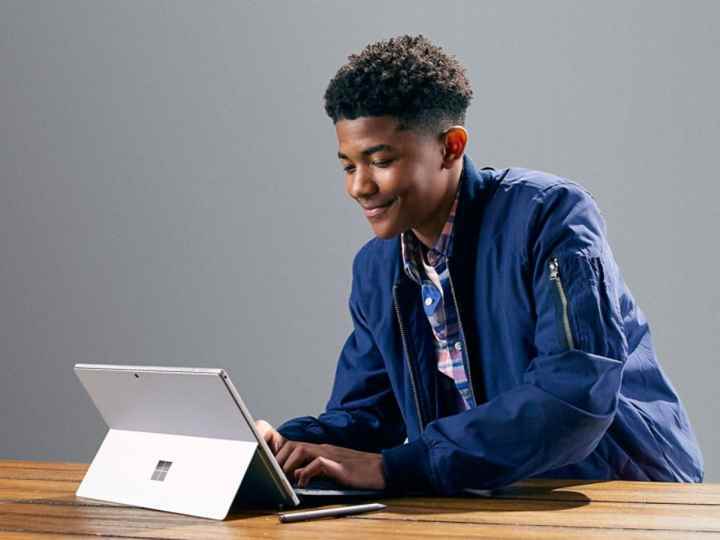 Tip Kapaklı bir masada Microsoft Surface Pro 7 kullanan öğrenci.