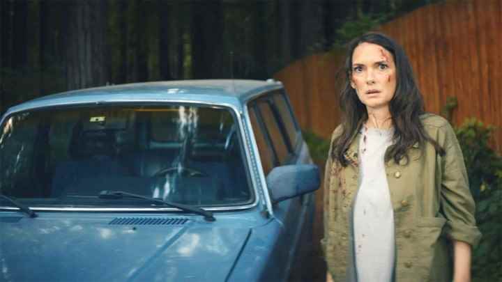 Winona Ryder, Gone in the Night'ta mavi bir arabanın yanında duruyor.