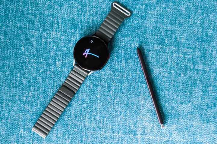 Mavi bir arka plan üzerinde Galaxy S22 Ultra'dan S Pen ile Samsung Galaxy Watch 4.