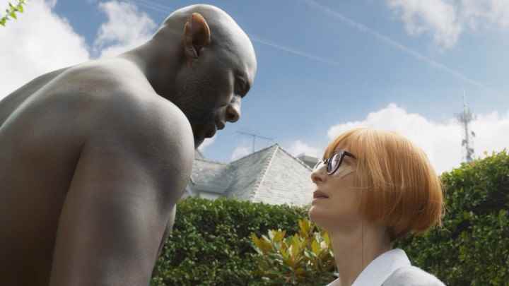 Idris Elba, Tilda Swinton'ın üzerinde görünüyor.