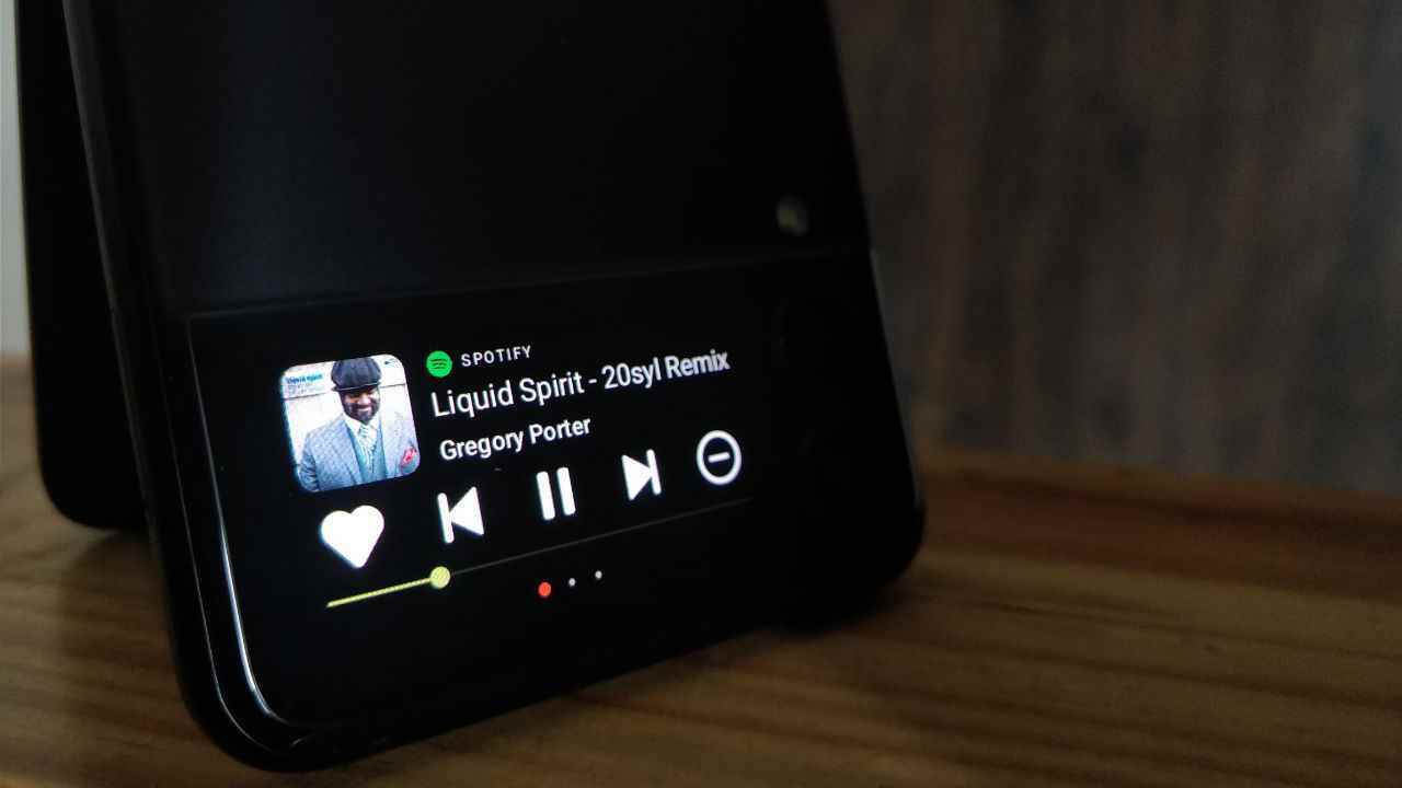 CoverScreen OS uygulamasını çalıştıran ve medya oynatıcı widget'ını gösteren bir Galaxy Z Flip 3 resmi