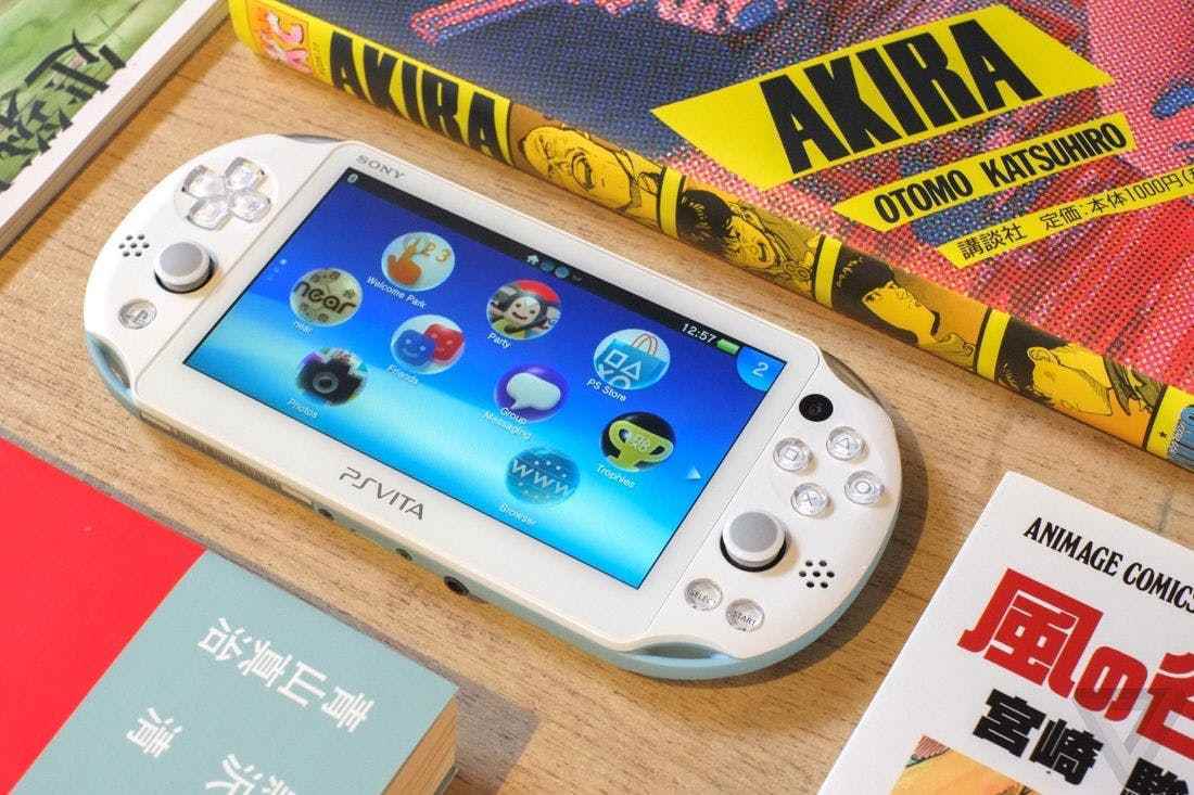 PS Vita, bir Akira mangası ve diğer birkaç kitap arasında yuvalanmış bir masanın üzerinde oturuyor.