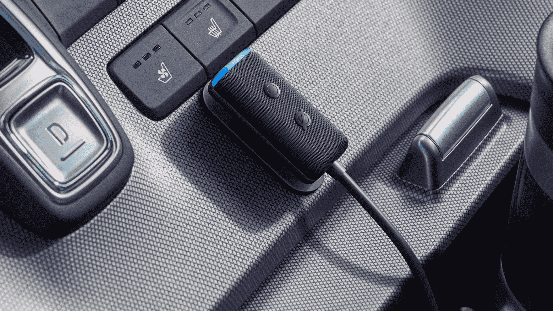 Bir arabanın orta konsoluna, koltuk ısıtıcısı kontrolleri için düğmelerin hemen altına monte edilmiş bir Amazon Echo Auto.