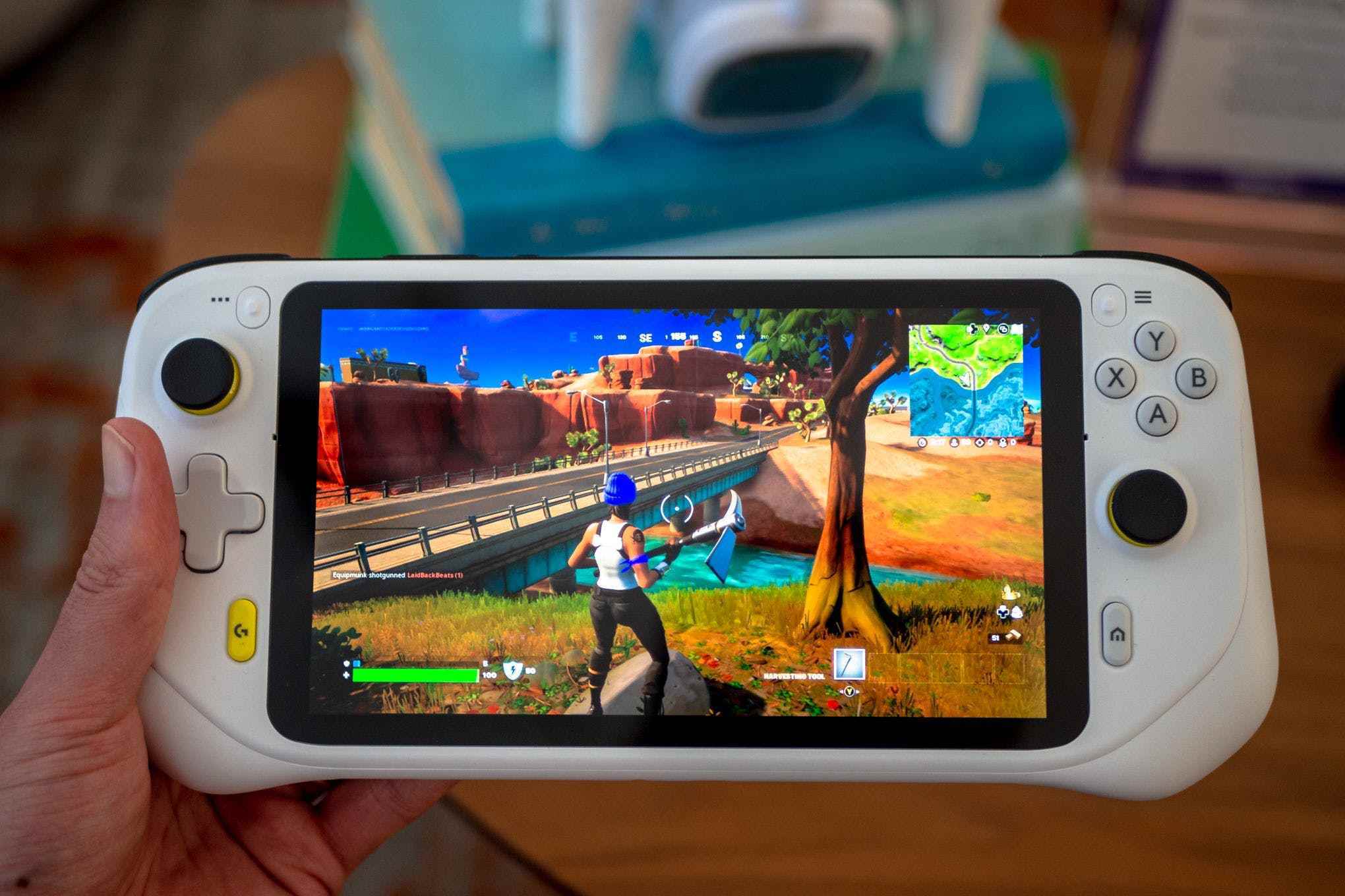 Logitech'in G Cloud Gaming Handheld'ini bir elinizde tutar.  Bir karakterin bir uçurumdan ufka baktığı Fortnite oyununu gösteriyor.