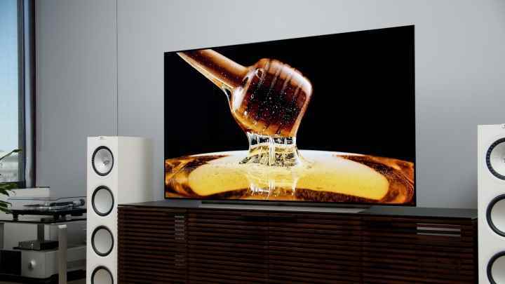 Hoparlörlü bir ev sineması ayarına yerleştirilmiş, ekranında bal görüntüsü olan LG C1 OLED 4k TV.