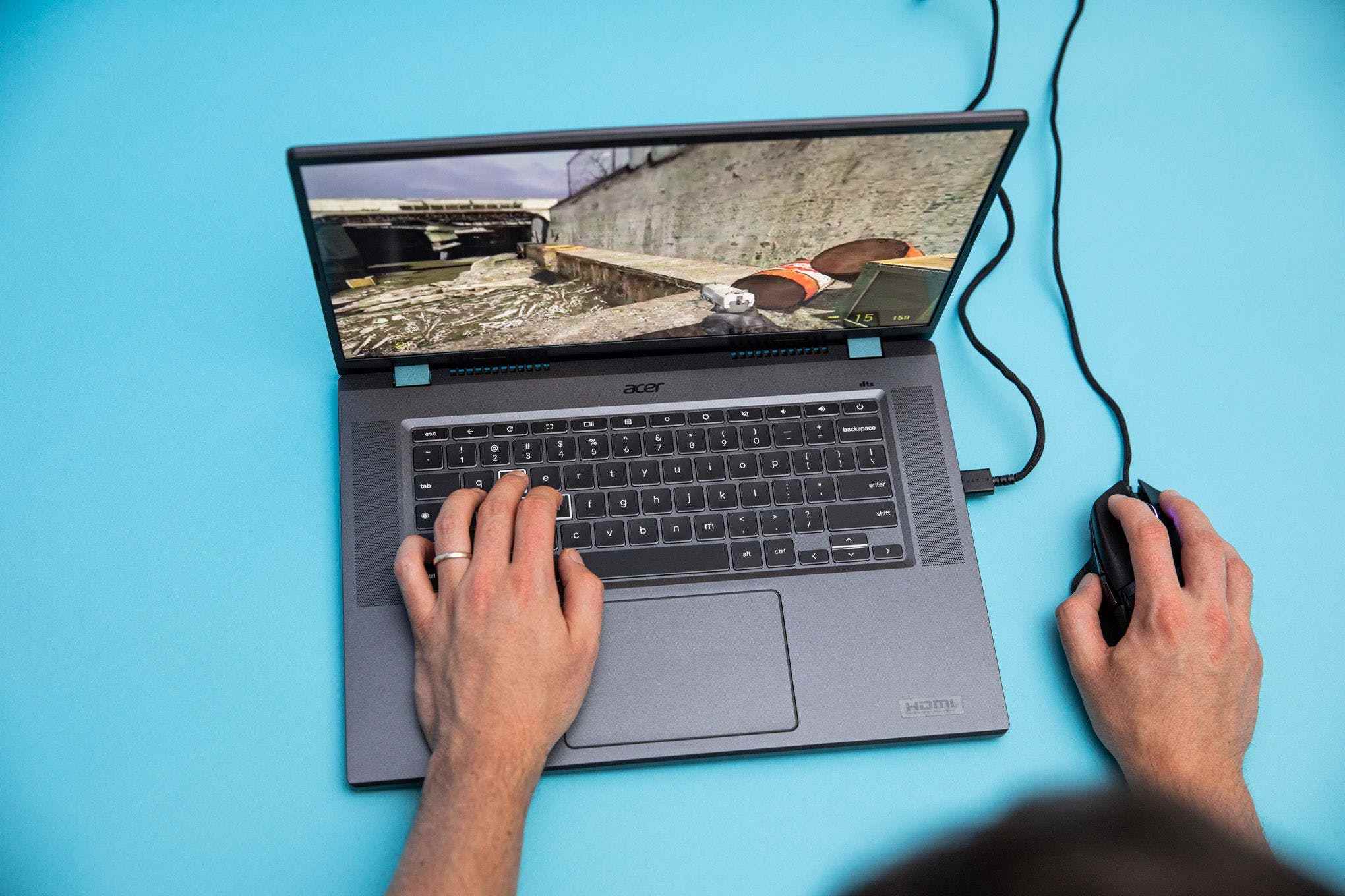 Acer Chromebook 516 GE, fare takılı, Half Life 2 oynuyor. Yazarın sol eli, hareket etmek için dizüstü bilgisayarın W, A, S ve D tuşlarına yerleştirildi.