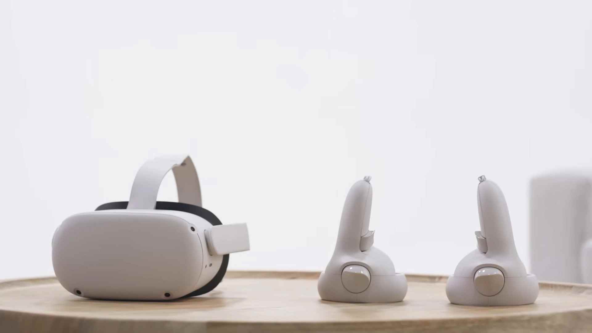 Ahşap bir yüzeyin üzerinde bir Oculus Quest 2 başlığı (solda) ve denetleyicileri (sağda)