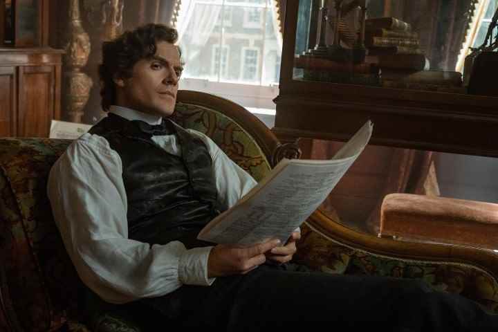 Henry Cavill, Enola Holmes 2'den bir sahnede Sherlock Holmes olarak arkaya yaslanıyor.