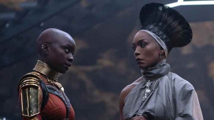 Danai Gurira ve Angela Bassett, Black Panther: Wakanda Forever'dan bir sahnede birbirlerine dikkatle bakıyorlar.