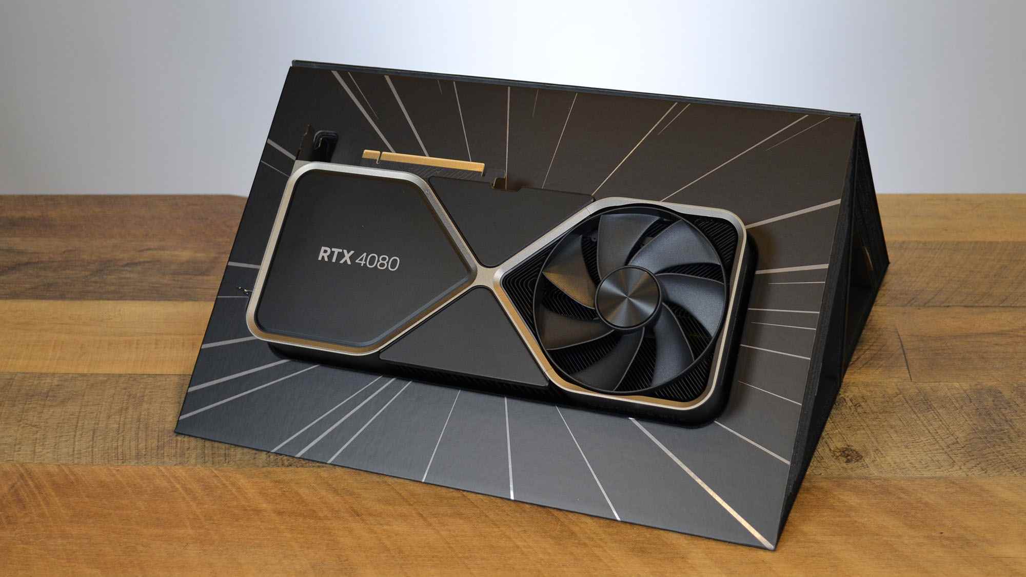 Beyaz bir panelin önünde ahşap bir masa üzerinde bir Nvidia GeForce RTX 4080