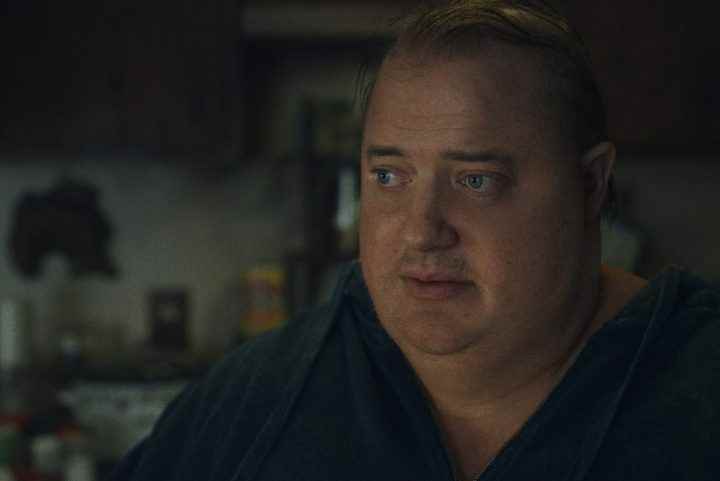 Brendan Fraser, The Whale'den bir sahnede oturuyor ve bakıyor.