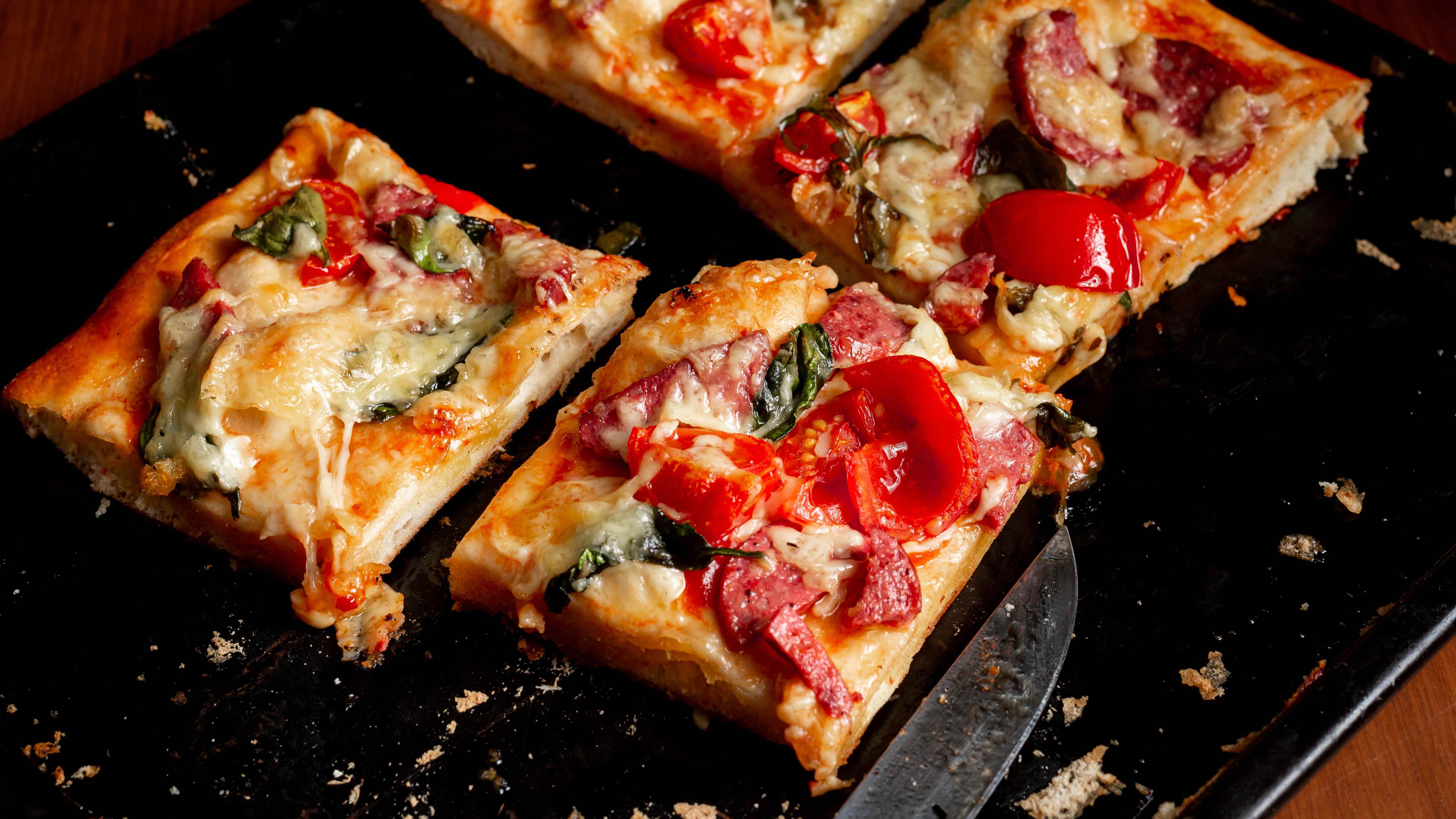 Pizza kareler halinde kesin ve bir fırın tepsisine ayırın