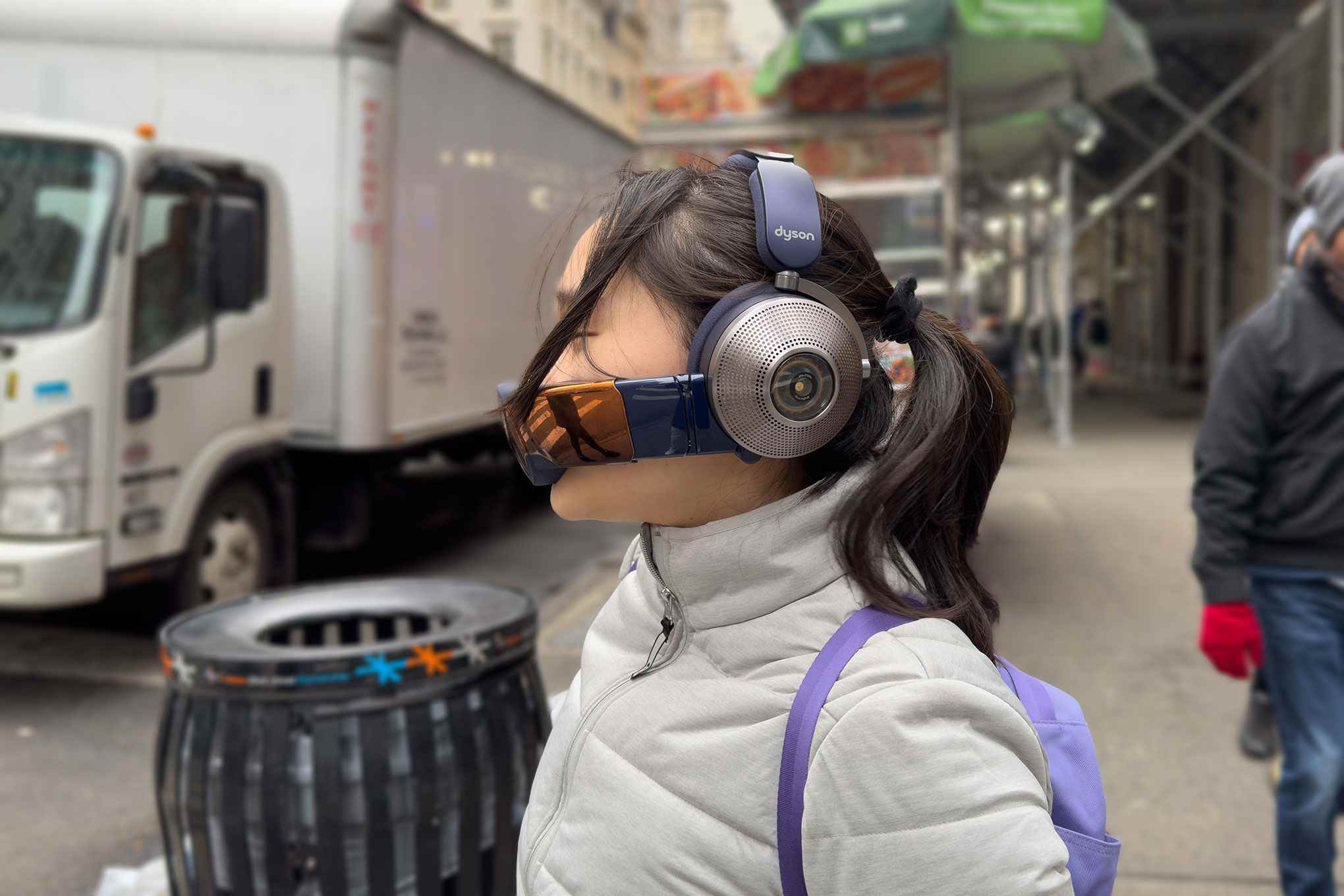 New York'ta Dyson Zone kulaklık ve siperlik takan bir kadının yandan görünümü