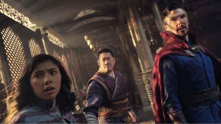 Doctor Strange in the Multiverse of Madness'tan bir sahnede Xochitl Gomez, Benedict Wong ve Benedict Cumberbatch kameraya bakıyor.