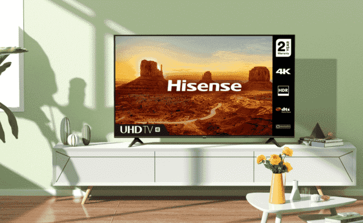 Beyaz medya konsolu üzerinde Hisense 70 inç A6G Sınıfı 4K TV.  Güneş ışığı ve gölgeler oturma odasına düşüyor.