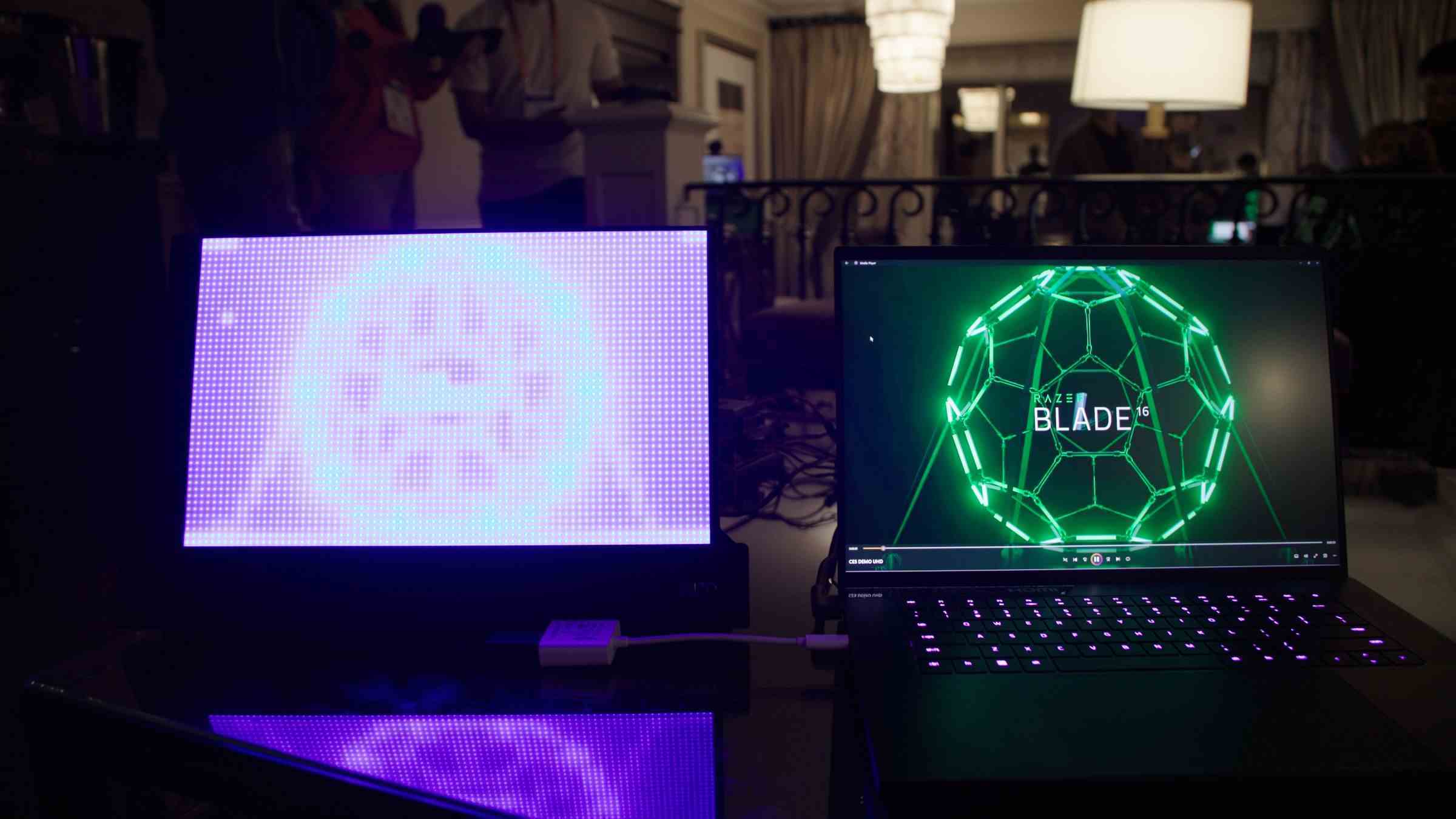 Razer Blade 16, bir masa üzerinde görüntülenen Mini LED'lerin yansıtma panelinin yanında.