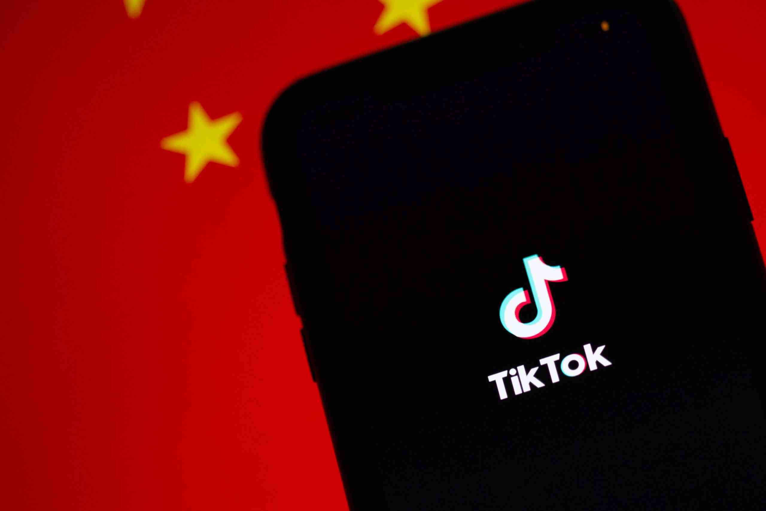 Çin bayrağının önünde TikTok logosu bulunan bir telefon.