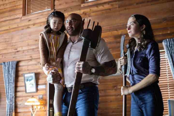 Kristen Cui, Dave Bautista tarafından tutulurken, Abby Quinn kaba bir silahla yakınlarda duruyor.