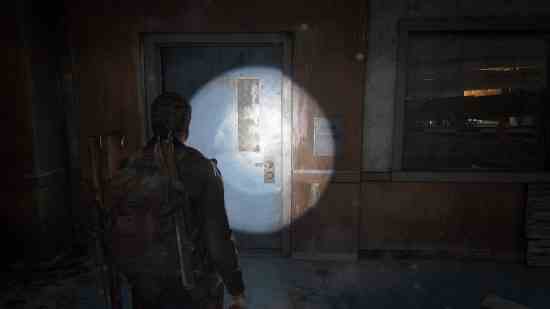 The Last of Us eğitim kılavuzları: Bir adam el fenerini duvara tutuyor.