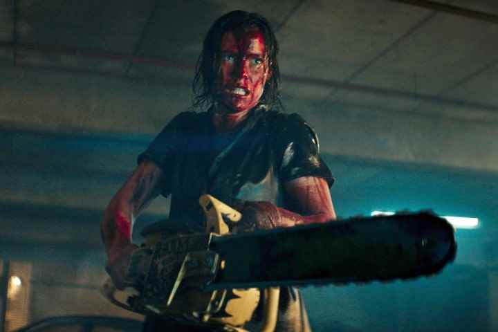 Evil Dead Rise'da bir kadın elektrikli testere kullanıyor.