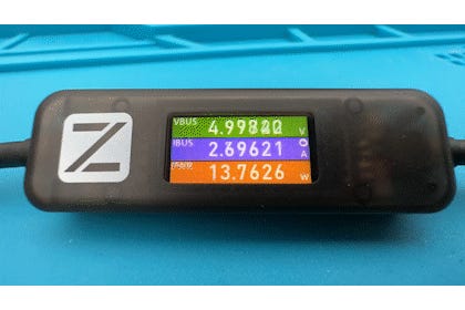 ChargerLAB Power-Z AK001 ekranı, mavi bir arka plan üzerinde voltaj, amperaj ve gücü gösterir