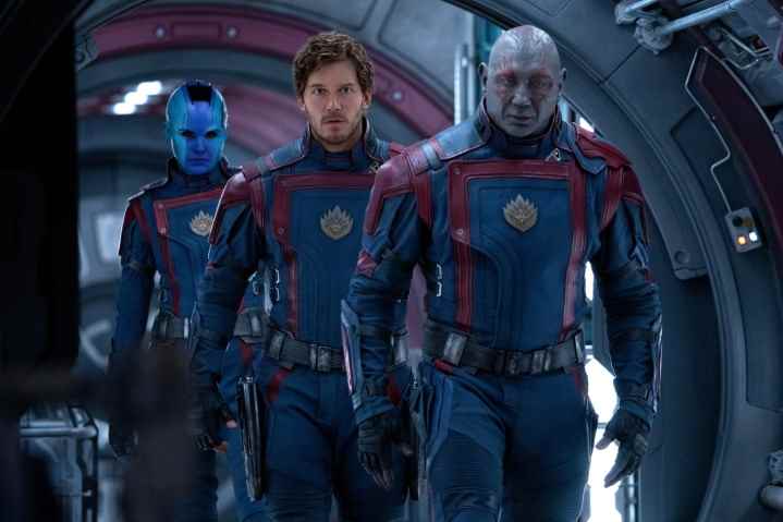 Galaksinin Koruyucuları Vol.  3' Siyah ve kırmızı üniformalar giyen Nebula (Karen Gillan), Star-Lord (Chris Pratt) ve Drax (Dave Bautista), metal bir gemi koridorunda yürüyorlar.