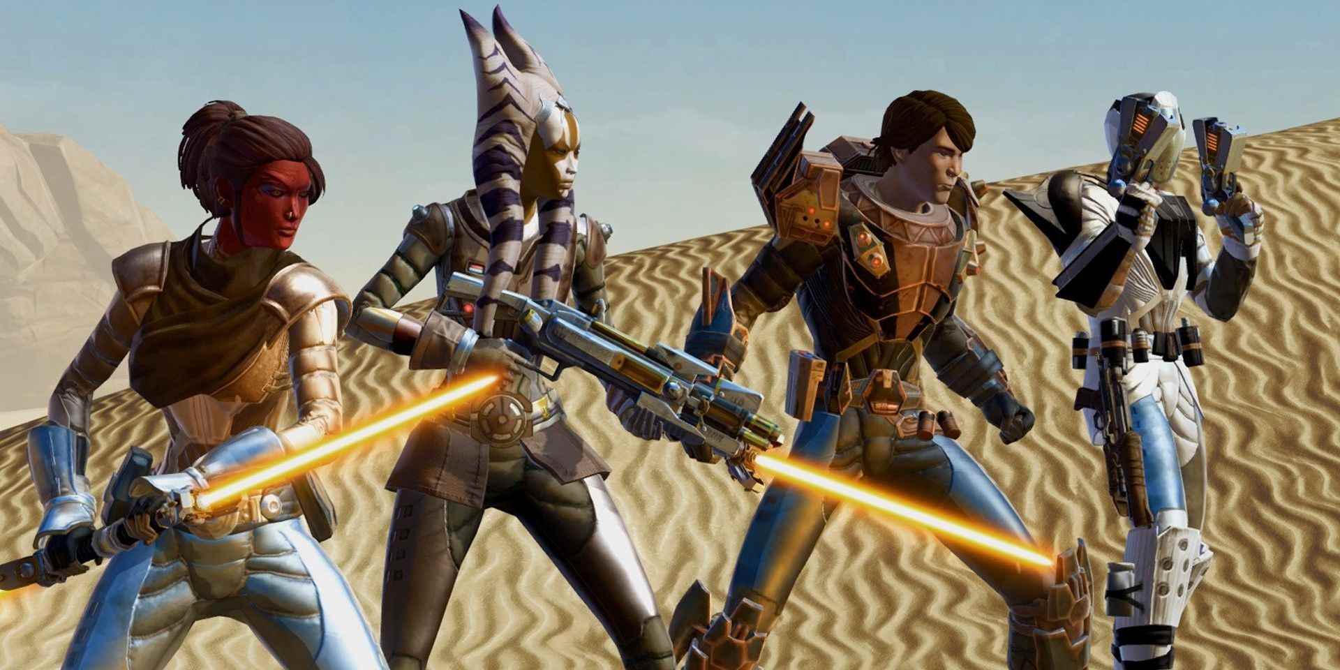 Star Wars: The Old Republic'te fütüristik zırh giyen ve ışın kılıcı veya patlayıcı kullanan dört oyuncu karakteri kum tepelerinde hazır bekliyor
