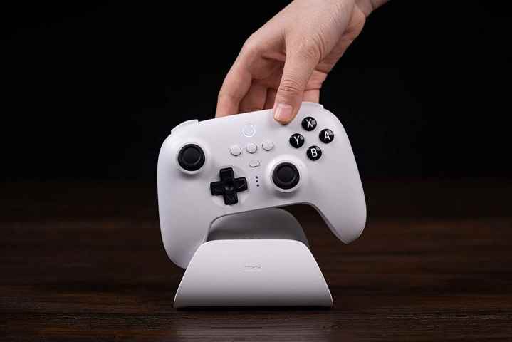 Bir el, bir 8BitDo Ultimate kontrol cihazını alır.