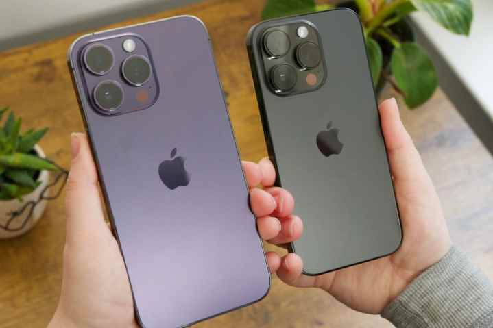 iPhone 14 Pro Max ve iPhone 14 Pro'yu yan yana tutan biri.