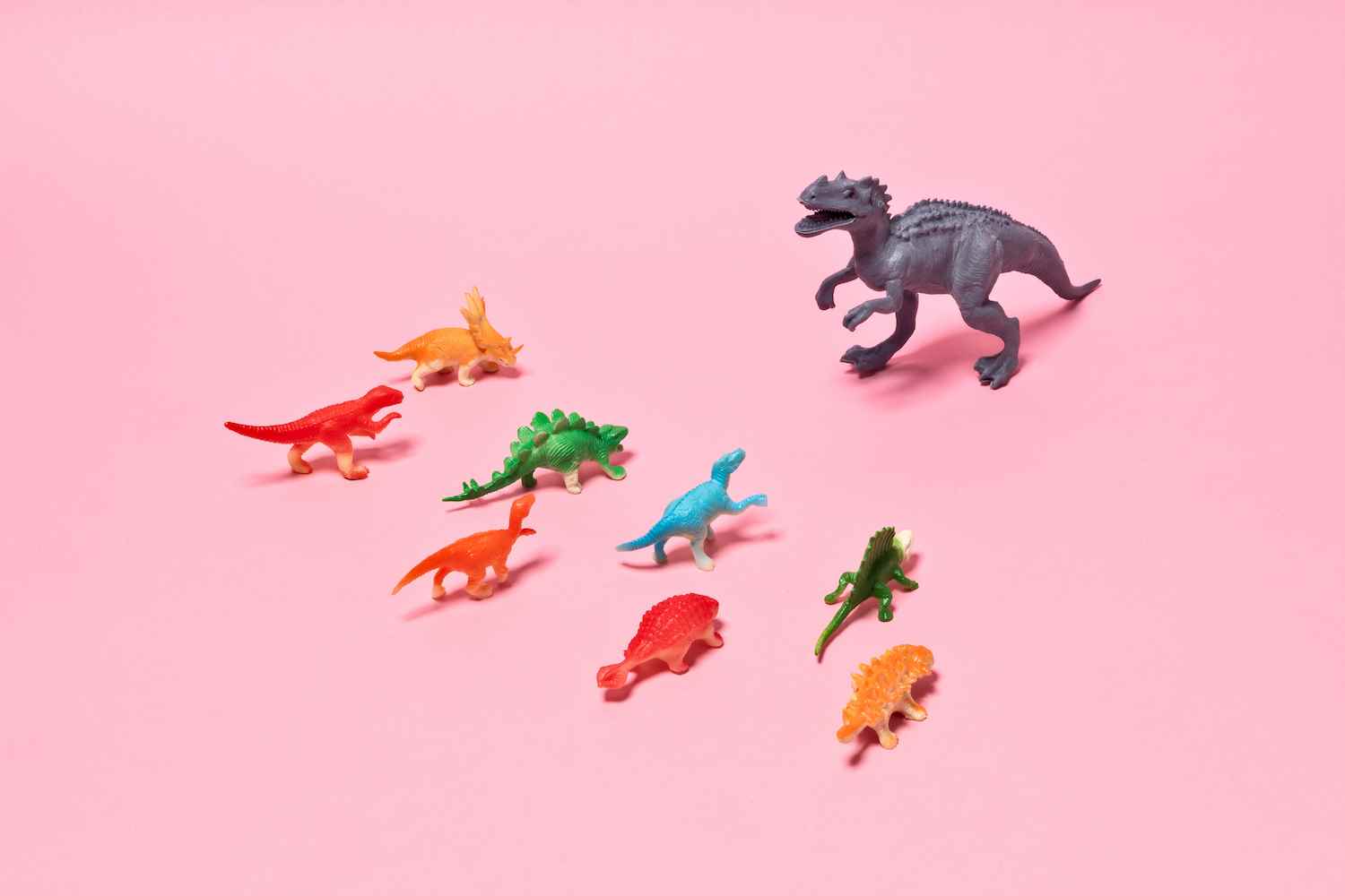 Oyuncak Dinozorlar Çatışması, Rex Dinozoru Pembe Arka Planda Kalabalıktan Uzak Duruyor.