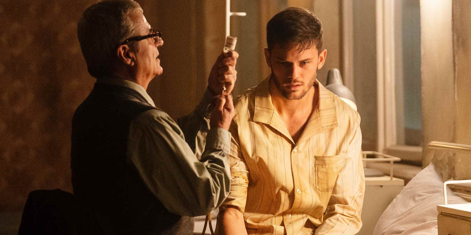 Jeremy Irvine, Treadstone'da bir doktor tarafından tedavi edilen bir hastane yatağında