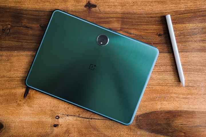 Ahşap bir masa üzerinde resmi Stylo kalem kalemi bulunan OnePlus Pad.