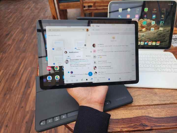 Galaxy Tab S8'i elinizde tutarak ve aynı anda çalışan birden fazla uygulamayı gösterirken.