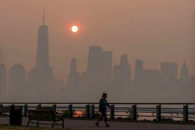 Bir kadın arka planda New York silüeti ile yürüyor.