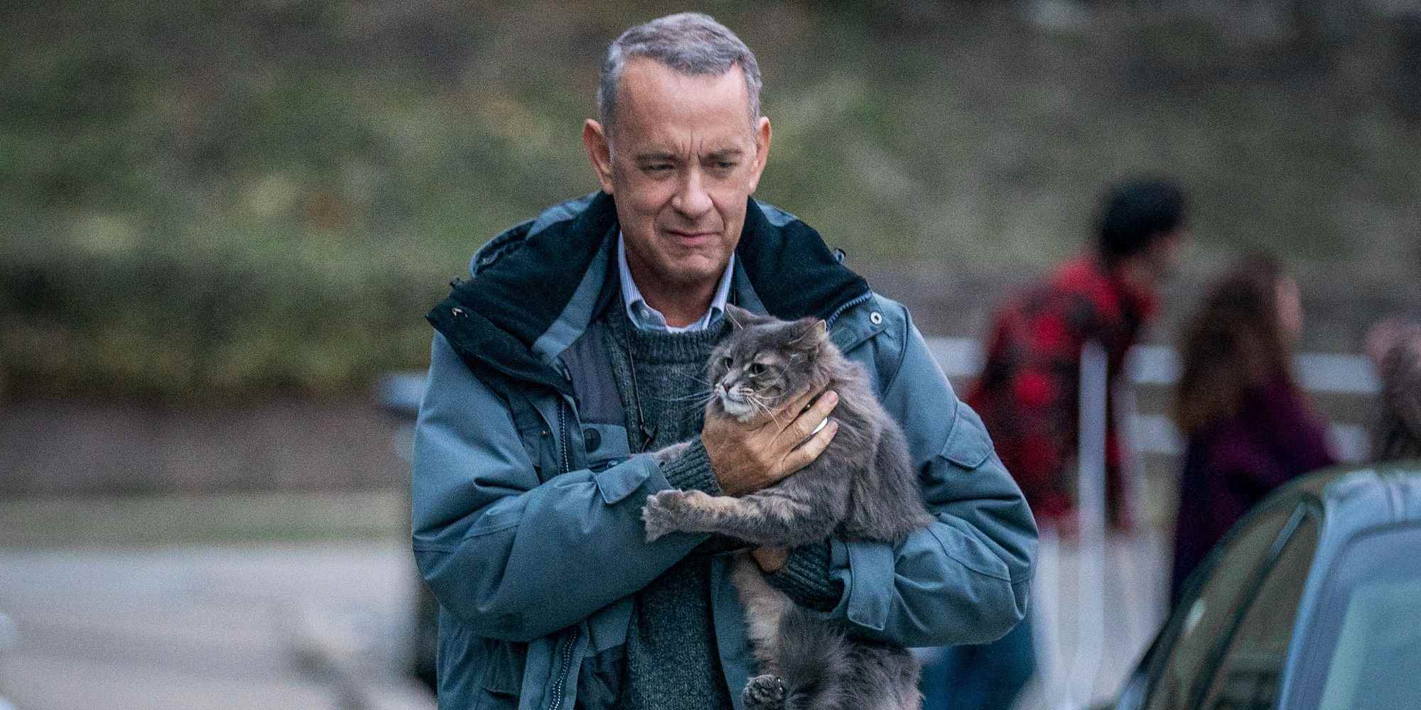A Man Called Otto'da Tom Hanks elinde bir kediyle gülümsüyor