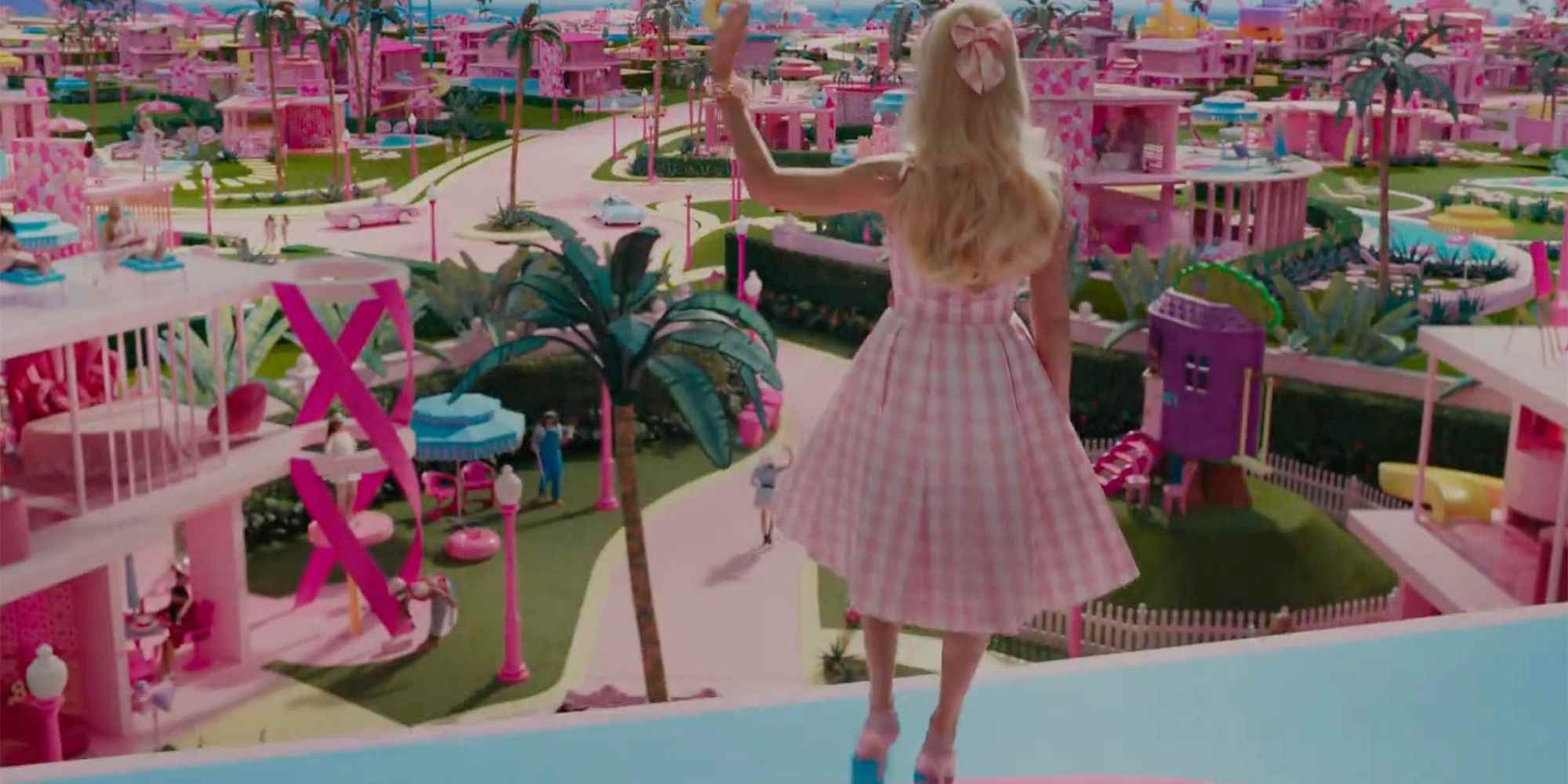 Margot Robbie, Barbie filminde pastel pembe bir oyuncak kasabasında el sallıyor