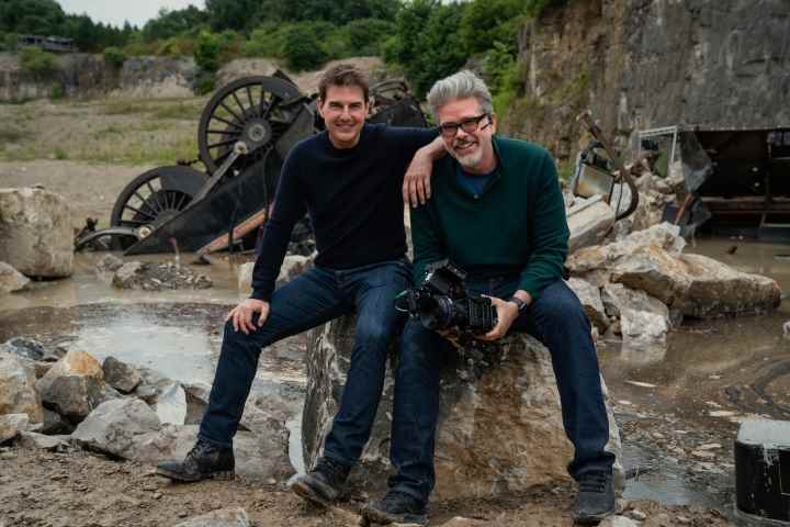 Tom Cruise ve Christopher McQuarrie, Mission: Impossible - Dead Reckoning Part One setinde bir kayanın üzerinde birlikte oturuyorlar.