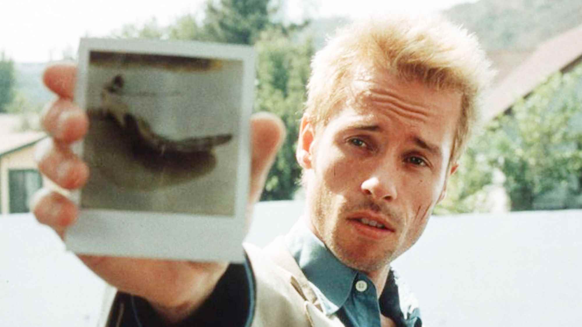 Guy Pearce, Memento'da elinde polaroid fotoğraf tutan Leonard rolünde