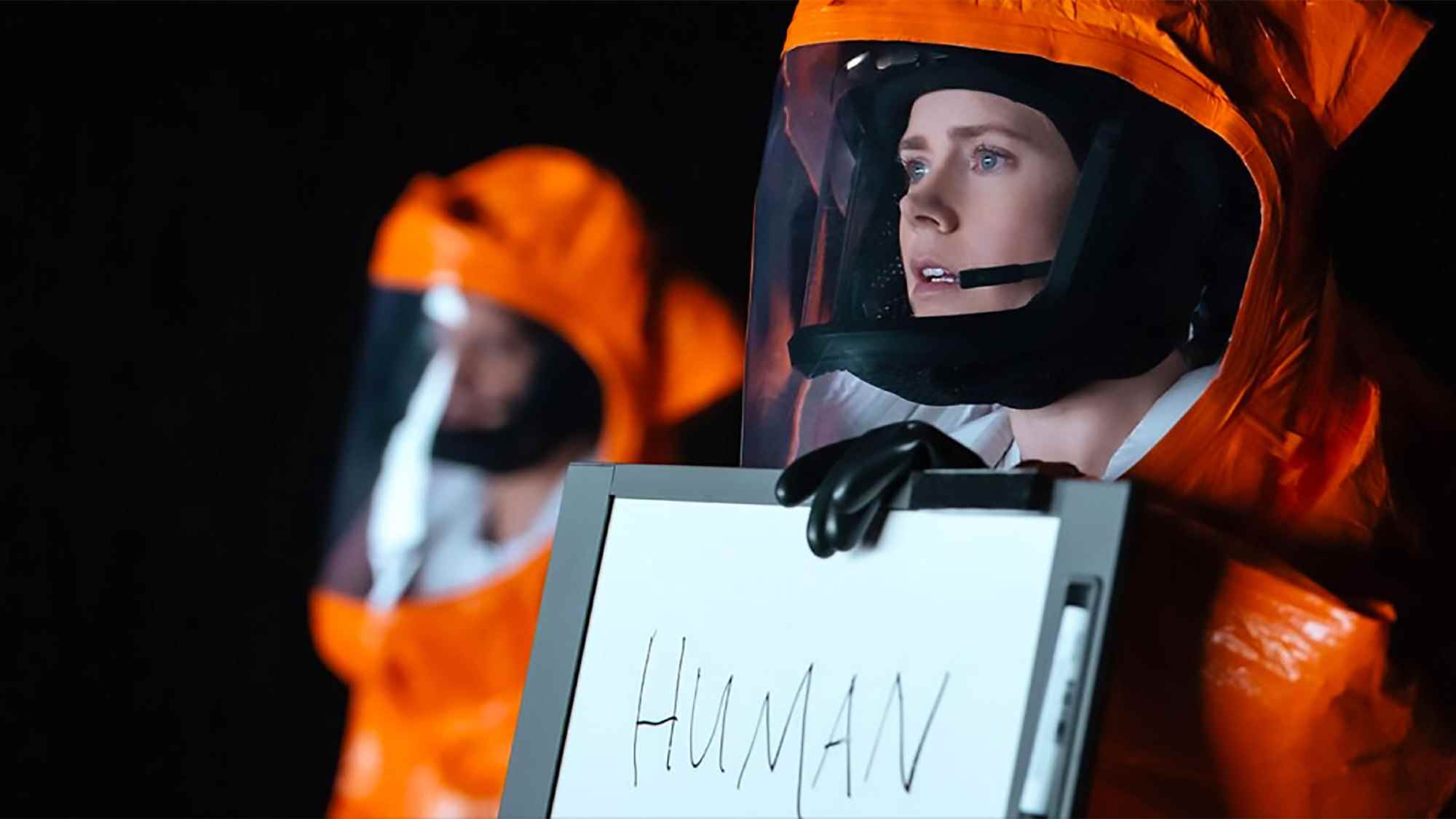 Amy Adams, Arrival'da İNSAN yazan bir tabelayı kaldırıyor