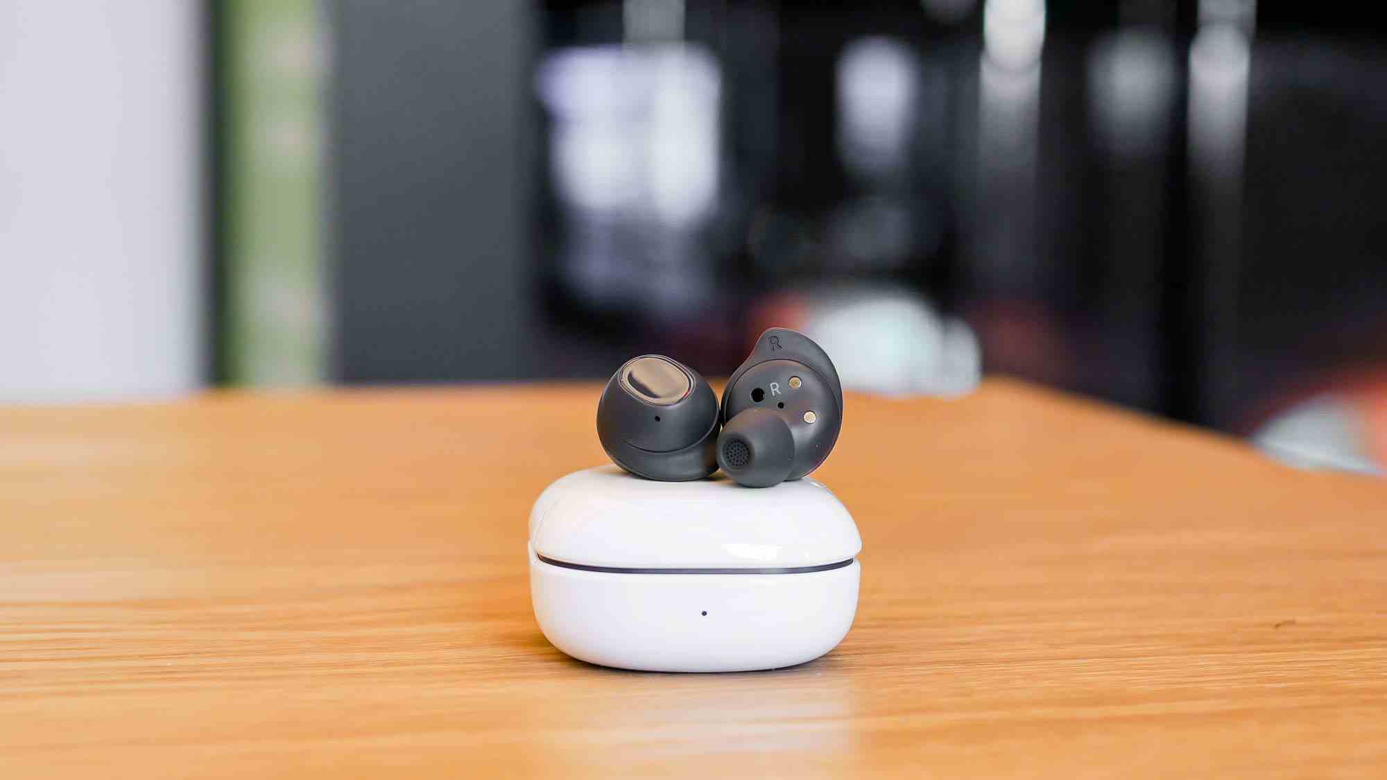 Elinizde tutulan Samsung Galaxy Buds FE kablosuz kulaklıklar.