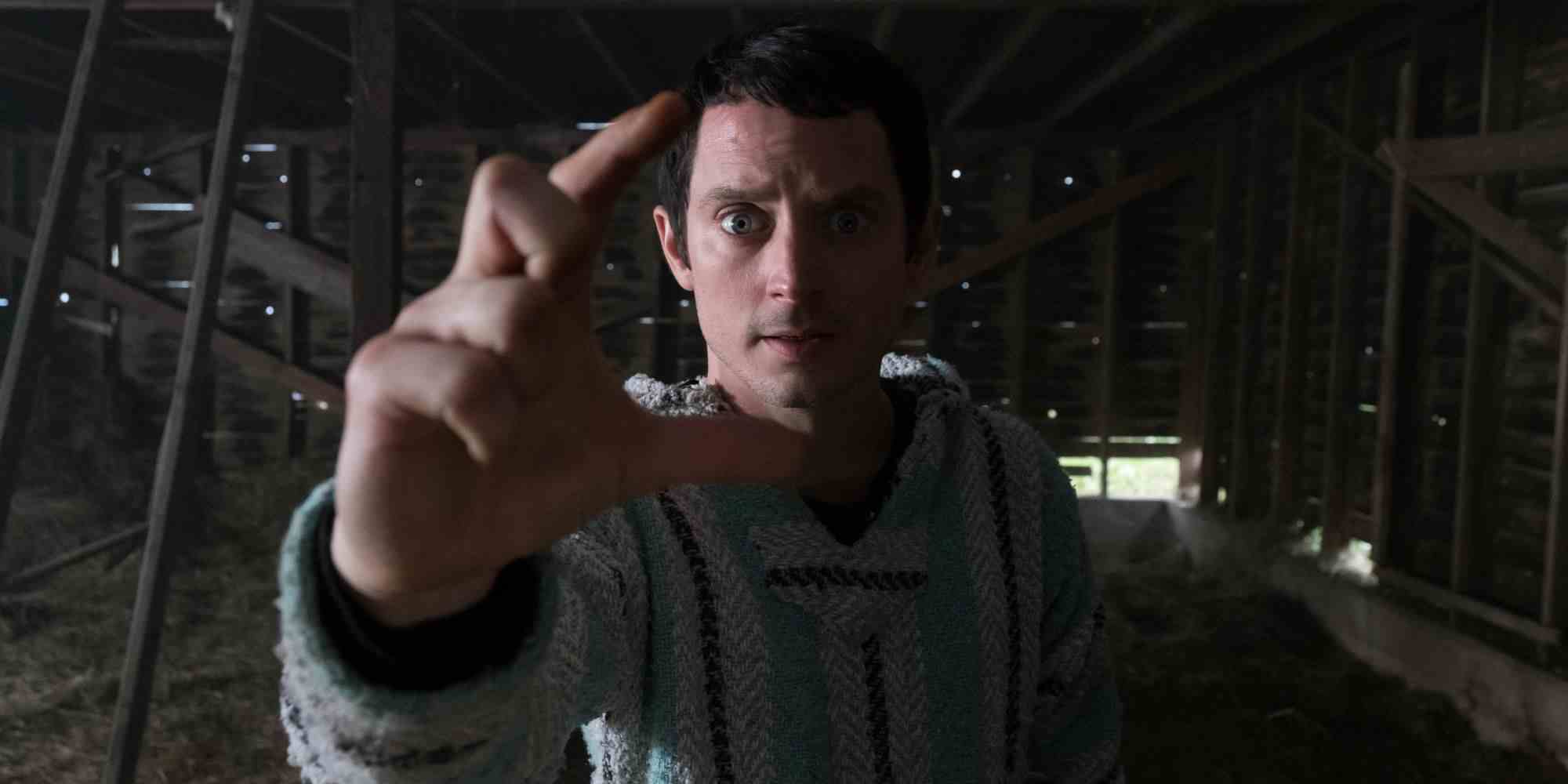 Dirk Gently'nin Bütünsel Dedektiflik Bürosu'ndaki Todd Brotzman rolünde Elijah Wood, yüzün önünde el ele tutuşuyor