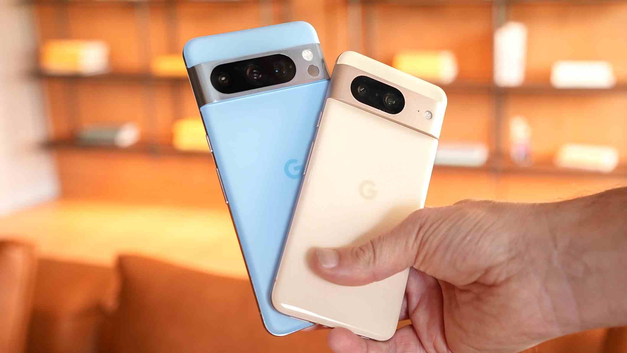 Elinde tutulan Google Pixel 8 ve Pixel 8 Pro.