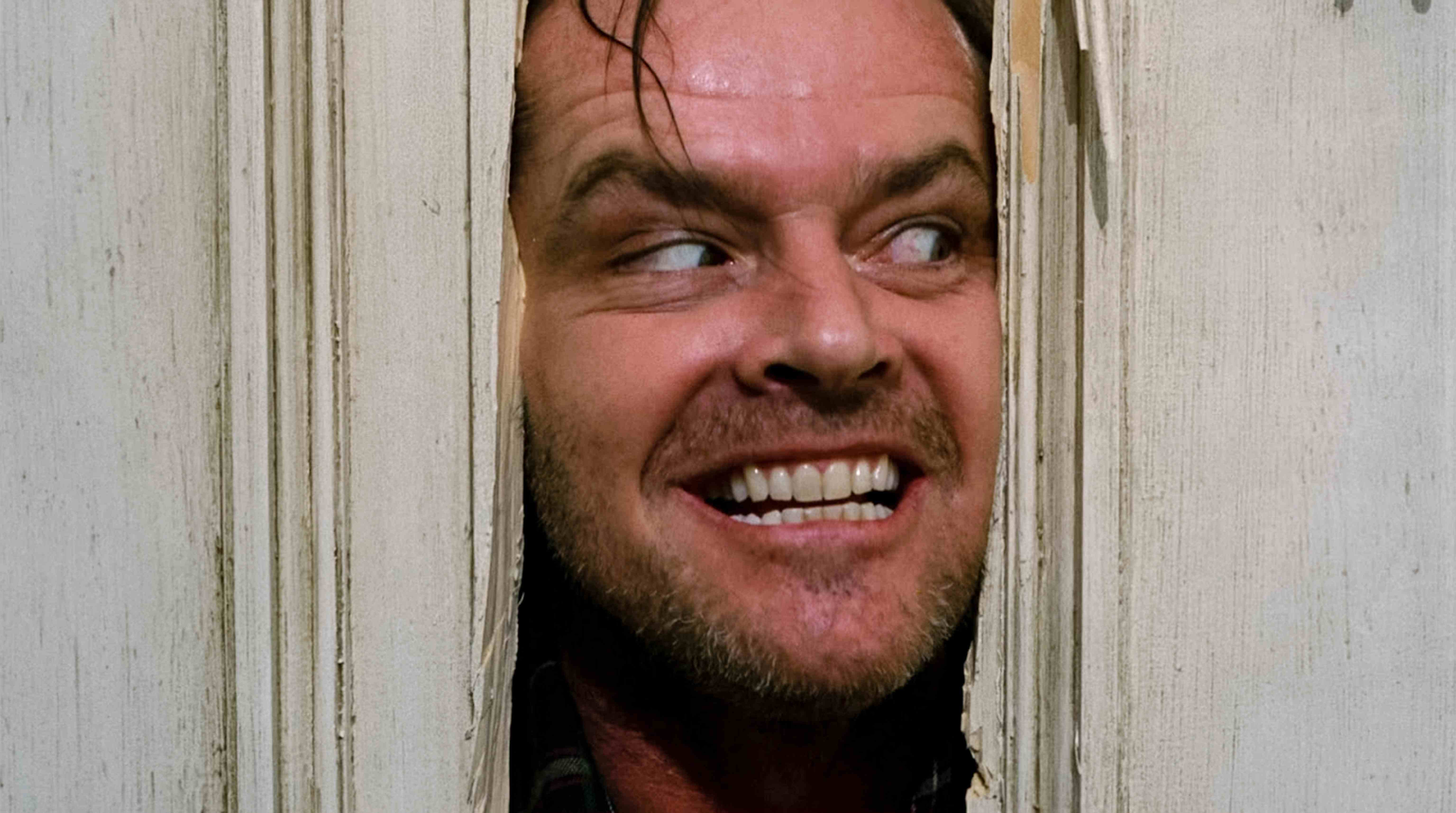 Jack Nicholson'ın canlandırdığı Jack Torrance, The Shining'de kafasını bir kapıdan dışarı uzatıyor.