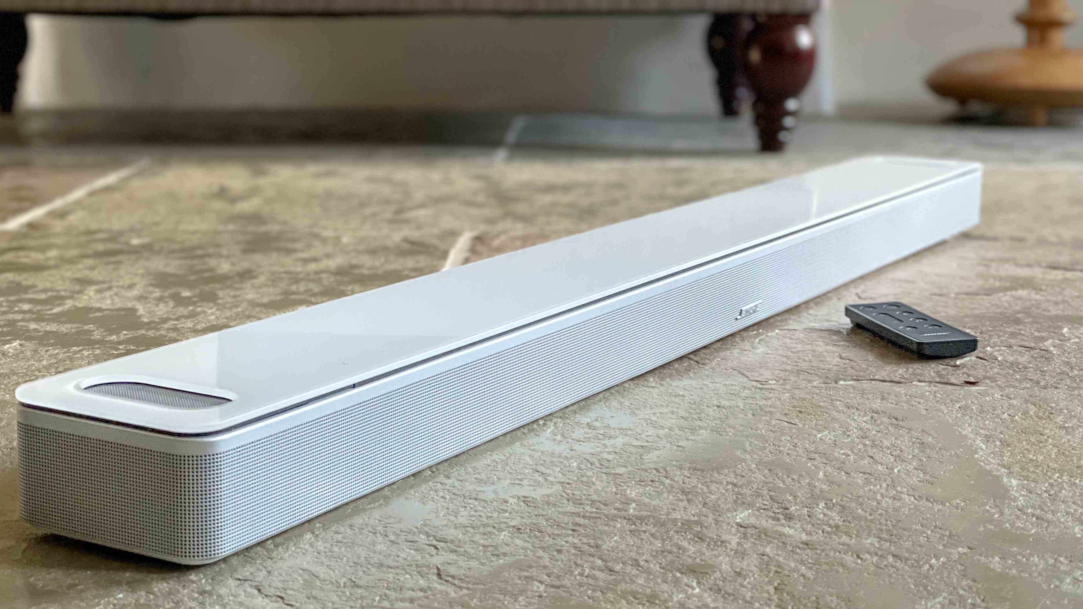 Beyaz renkli Bose Smart Ultra Soundbar taş zemine yerleştirildi