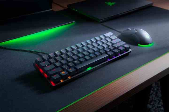 Gri ve yeşil masa yüzeyinde Razer Hunstsman Mini yüzde 60 klavye.