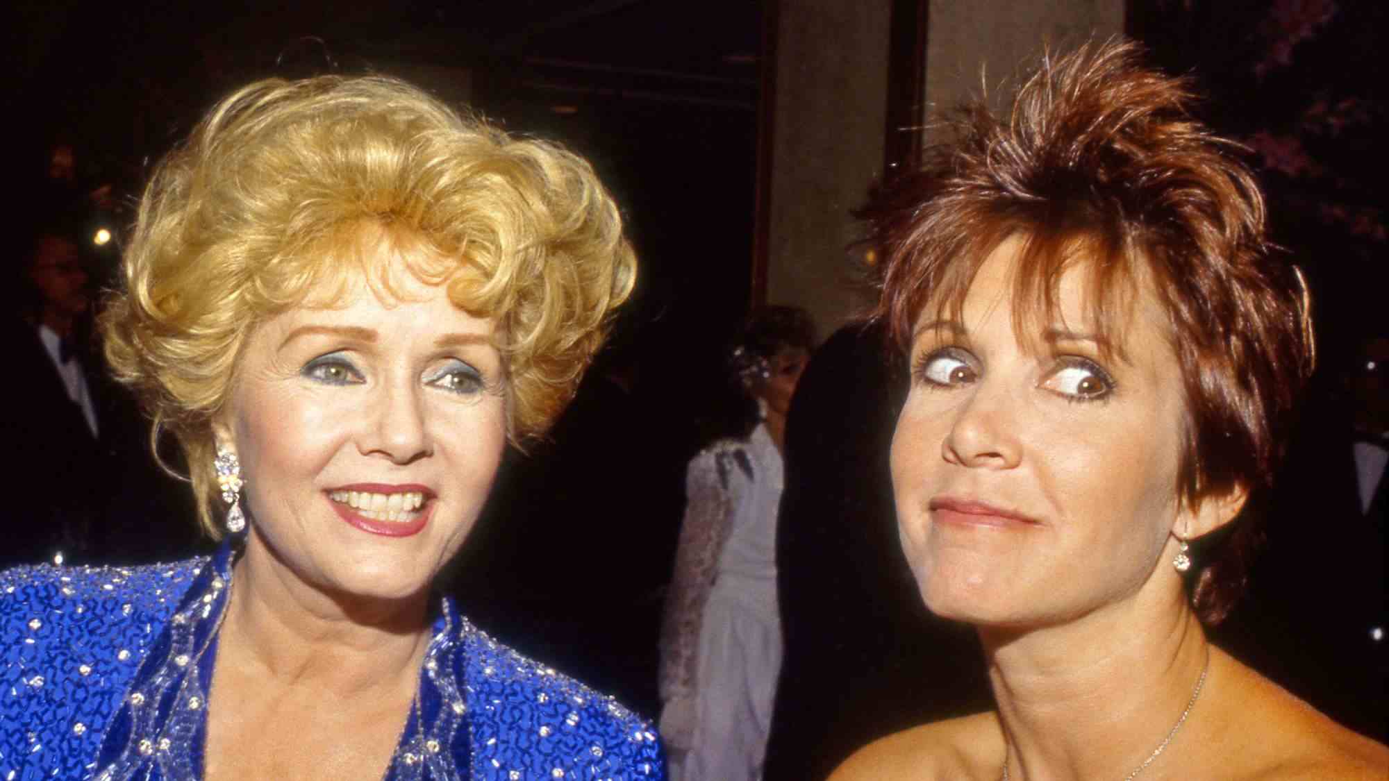 Debbie Reynolds ve Carrie Fisher, Beverly Hills, California'daki galada kameralar için kupa taktı